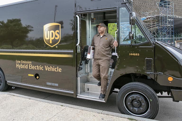 UPS delivery man going down the vehicle to deliver a package