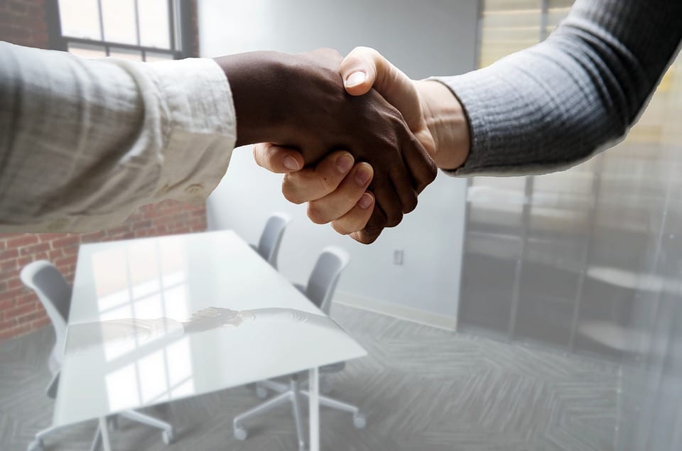 two persons shaking hands after an interview session